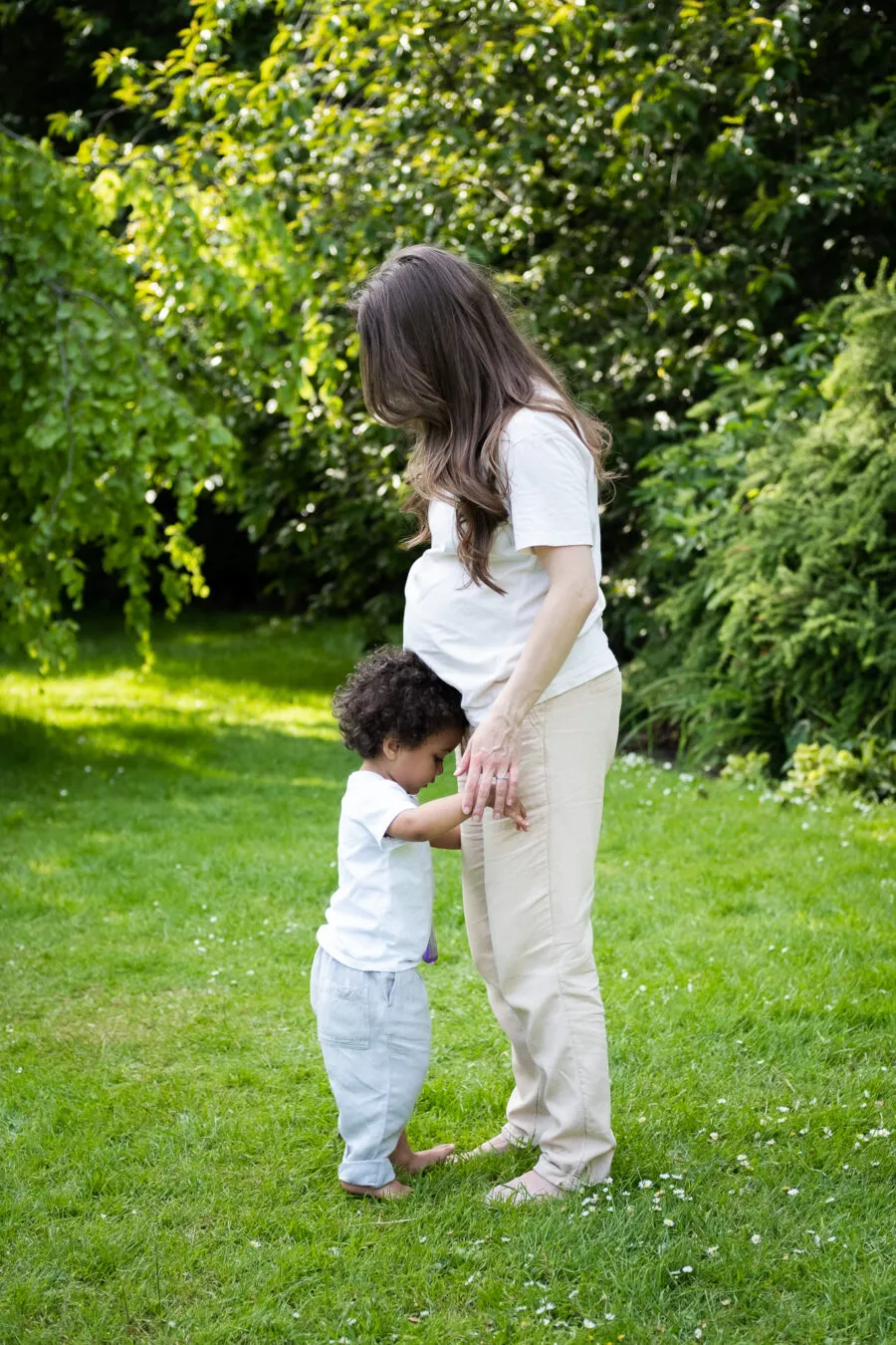 Pregnant woman and her first son in a park