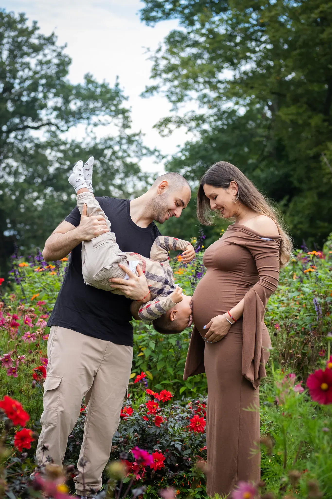 Maternity photoshoot for a family, little boy kissing mum's tummy