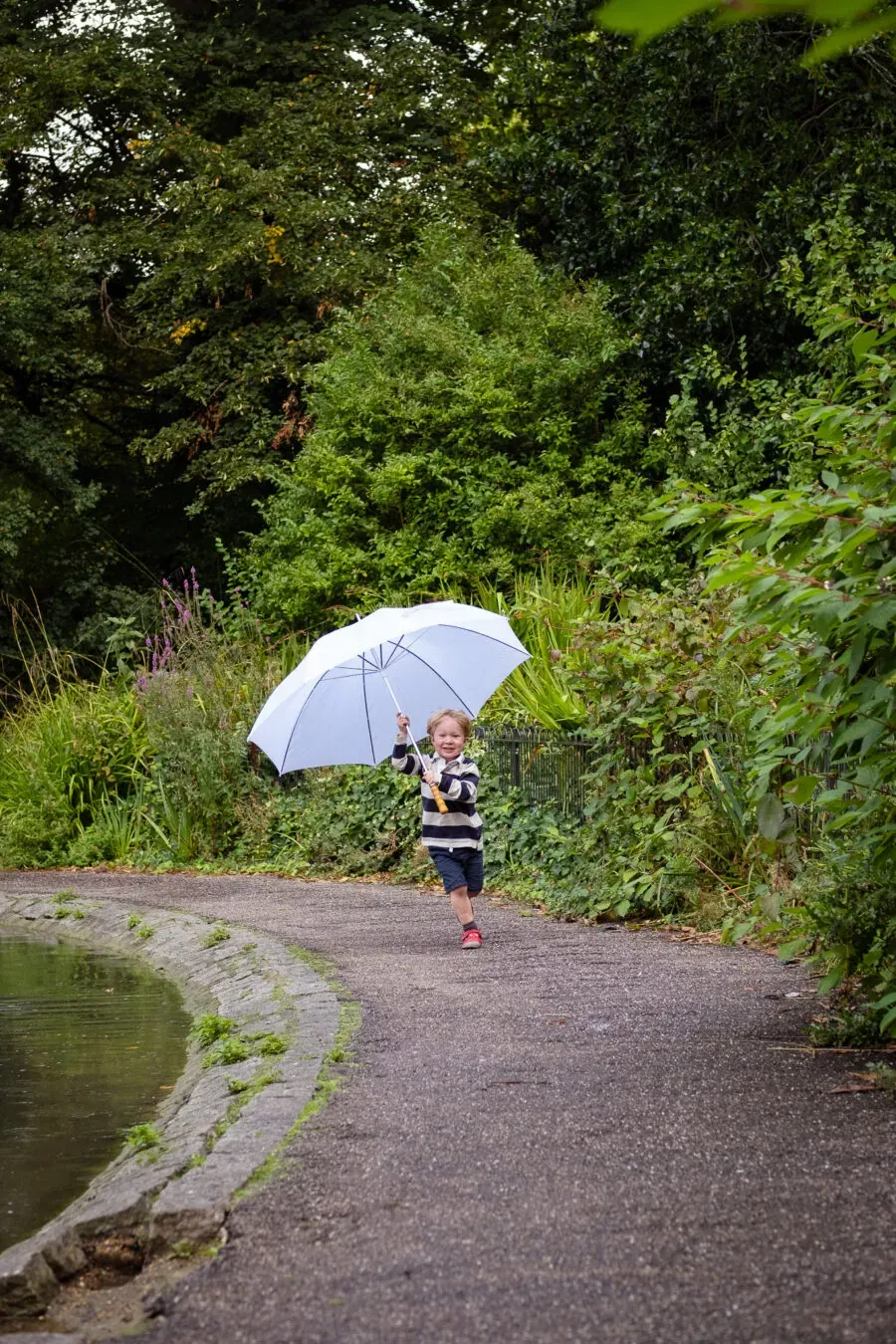 Little boy running with a white umbrella, family photography in park, MellSnap - Family Photographer