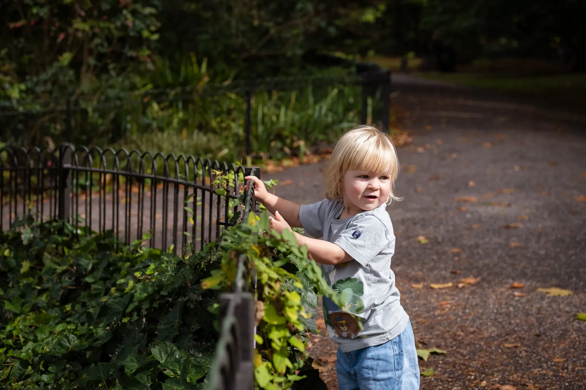 Little blonde girl in a park, exploring around London during an autumn photoshoot