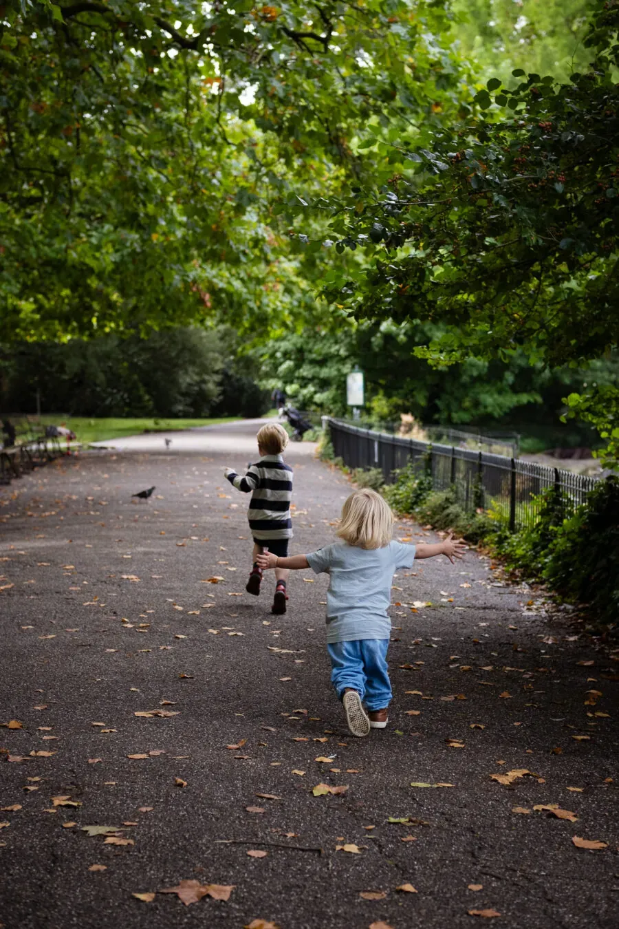 Brother and sister running in a park, enjoying the nice day