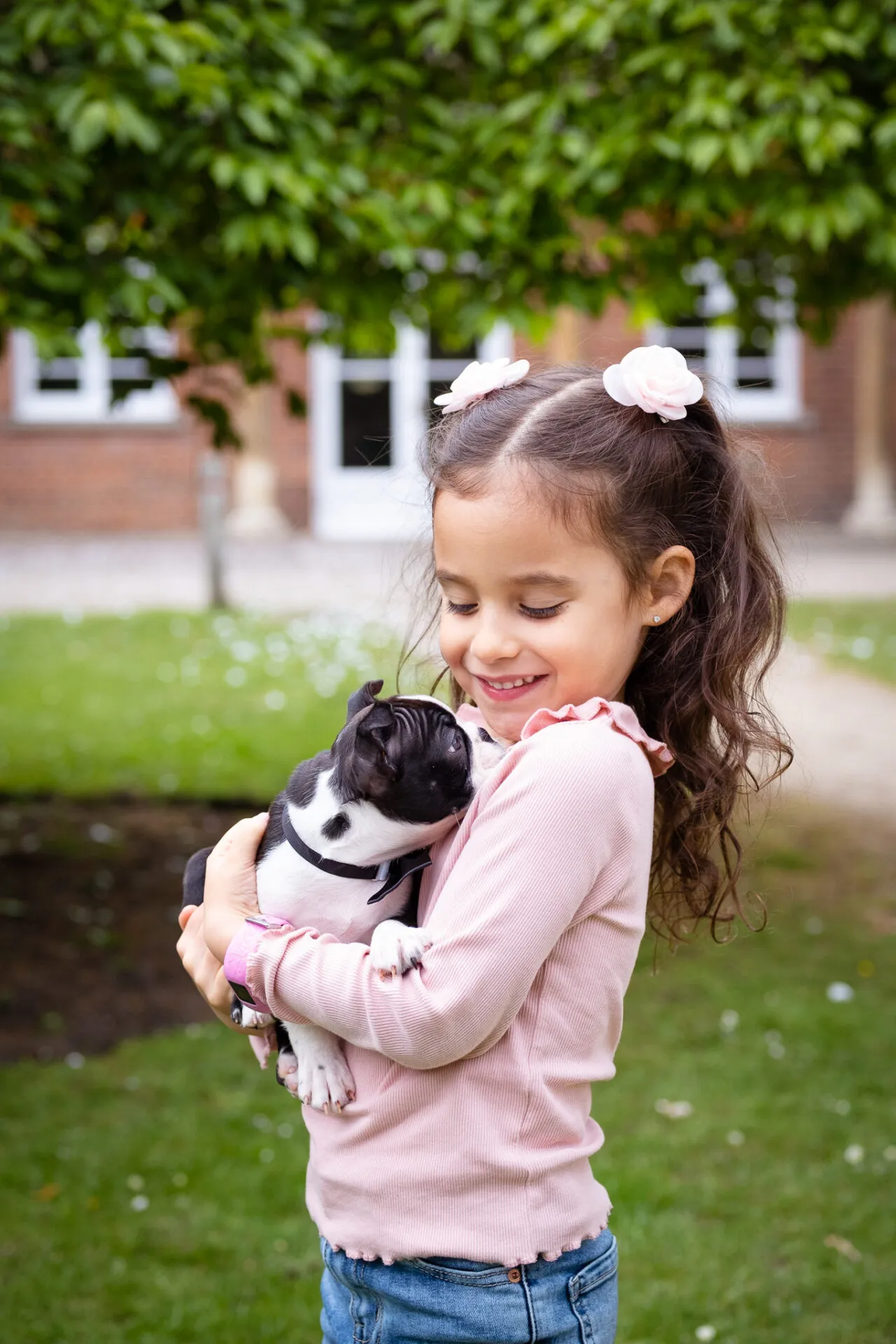 Little girl holding her puppy for a photoshoot