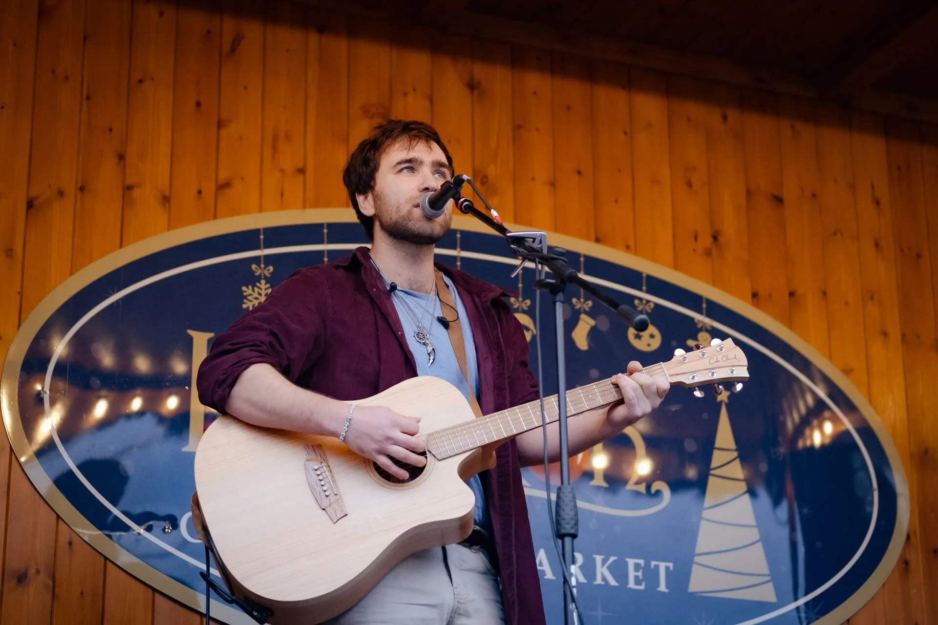 A man who is performing and playing a guitar on a christmas market