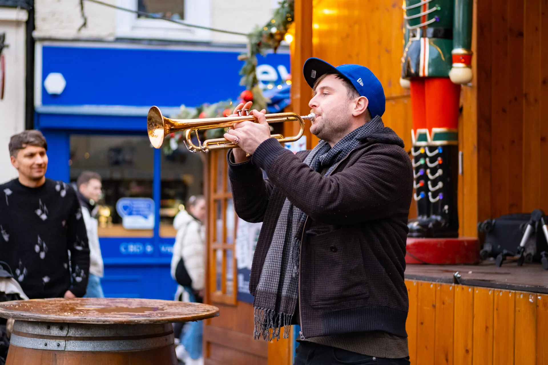 A man who is performing and playing a guitar on a christmas market