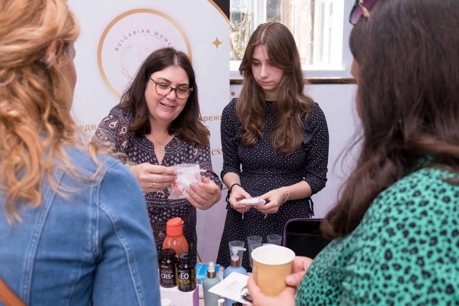 Two woman explaining to customers, bulgarian woman in business