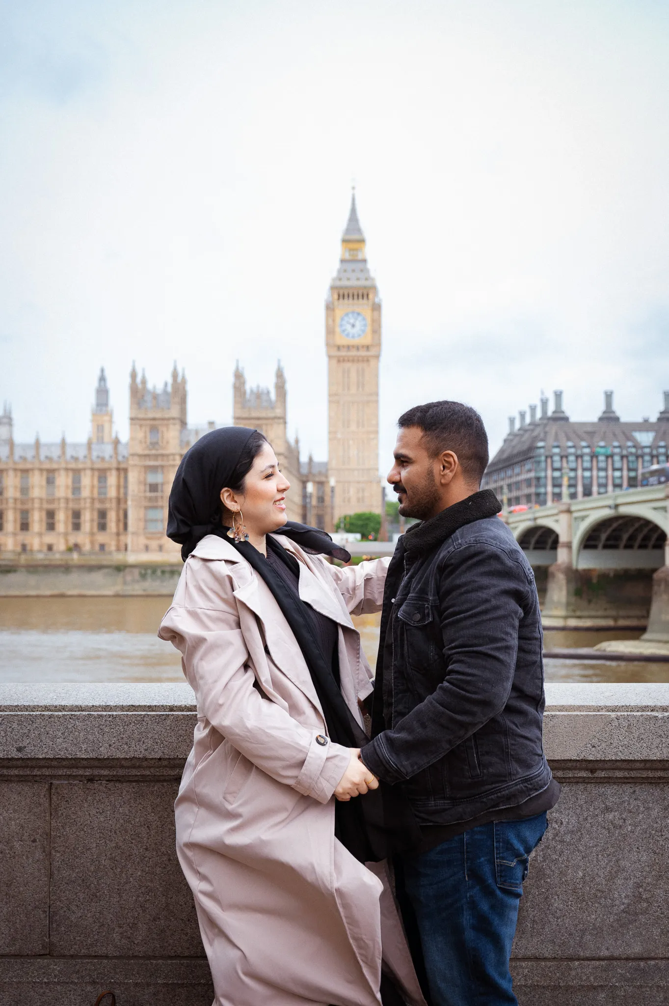 A love couple looking at each other, in front of the Big Ben, doing a maternity photoshoot in London