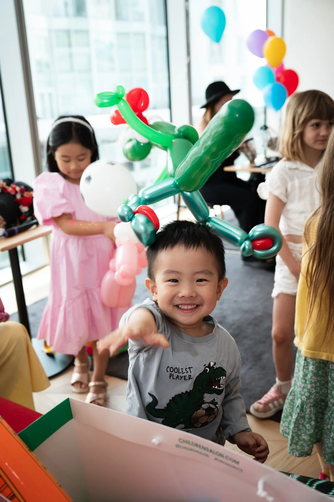 Smiling little boy wearing a balloon hat at a birthday party