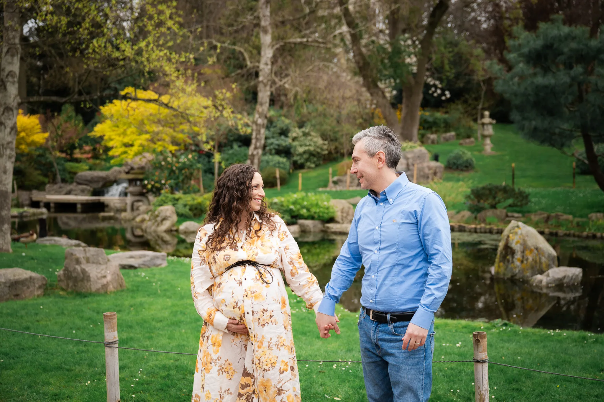 Pregnant mum and her husband holding hands in a Japanese garden