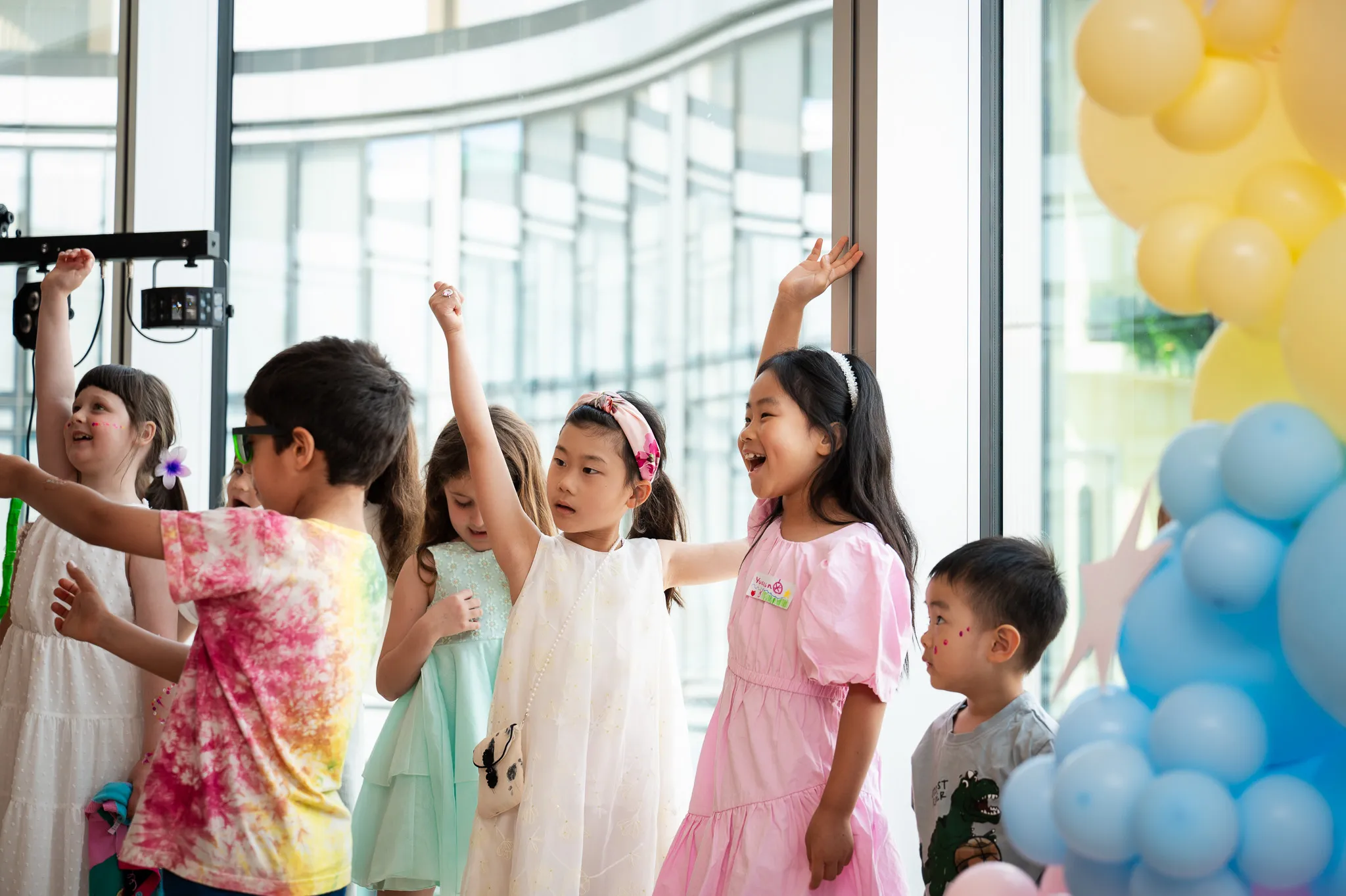 Children dancing with their arms in the air at a birthday party