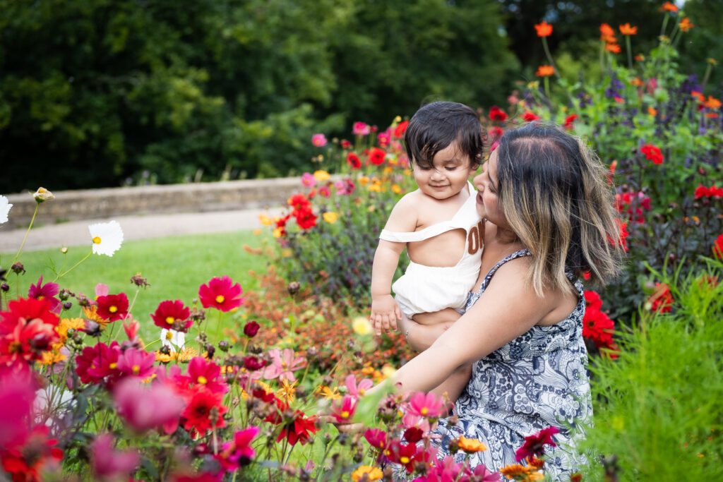 Mum with her son, looking at summer flowers, posing for a family photoshoot