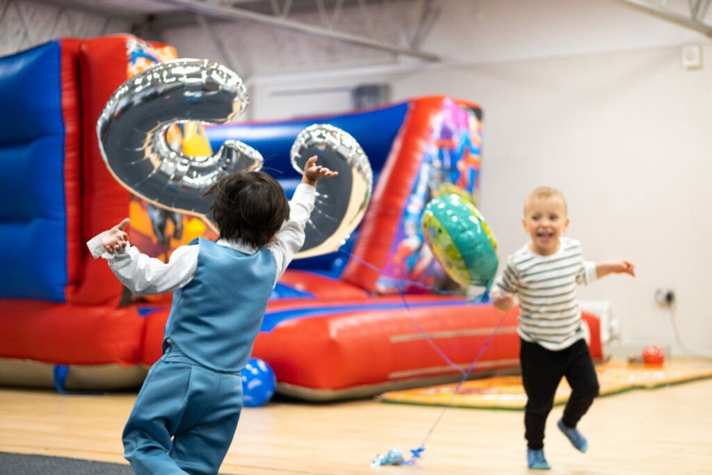 Two little boys running around a balloon